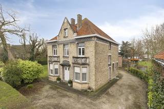 Dit charmante huis uit 1914 is een ware parel die zijn authentieke karakter tot op vandaag heeft behouden. Gelegen op een uitzonderlijk perceel van 1.500 m² biedt deze woning niet alleen een sfeervolle thuis, maar ook extra potentieel dankzij de twee loten bouwgrond die zich in de tuin bevinden.Bij het betreden van de woning kom je in een ruime marmeren inkomhal die meteen de tijdloze elegantie van het huis benadrukt. De authentieke vloeren in de woning zorgen voor een warme, historische sfeer. De zeer ruime woonkamer bestaat uit een zit- en eetgedeelte en sluit aan op een karaktervolle rotonde met prachtig zicht op de groene tuin.Op het gelijkvloers is er aan de voorzijde nog een ruime voorplaats, ideaal als bureau of praktijkruimte. Aan de achterzijde bevindt zich de keuken met directe toegang tot de tuin.De eerste verdieping telt vier grote, volwaardige slaapkamers en een badkamer met ligbad en lavabo. Via een vaste trap bereik je de zolderverdieping, waar het mogelijk is om een volwaardige extra verdieping te creëren, wat tal van bijkomende mogelijkheden biedt.Deze woning is niet enkel een plek om te wonen, maar een unieke kans om een stukje architecturale geschiedenis uit het begin van de 20e eeuw te bezitten en te vernieuwen naar eigen smaak. Bovendien ligt het huis op slechts 10 minuten wandelafstand van het stadscentrum, een zeldzame combinatie van ruimte, karakter en ligging.De algemene voorwaarden van Dewaele DIY kunt u steeds raadplegen via dewaele.com.