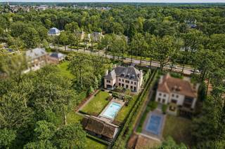 Deze stijlvolle manoir, gebouwd in 2013, werd met bijzondere aandacht voor detail gerealiseerd en afgewerkt met hoogwaardige materialen.<br /><br />U betreedt de woning via een statige inkomhal met trapzaal, vestiaire en gastentoilet. De lichtrijke leefruimte met open haard sluit naadloos aan op een bureau en een aparte eetkamer. De volledig geïnstalleerde keuken met kookeiland geeft uit op het overdekte terras met barbecue en de fraai aangelegde tuin. Verder beschikt het gelijkvloers over een praktische bijkeuken en een dubbele inpandige garage met automatische poorten.<br /><br />De ruime kelderverdieping biedt tal van mogelijkheden en leent zich uitstekend voor de inrichting van een ontspanningsruimte met bar, home cinema, biljartkamer en een aparte wijnkelder.<br /><br />Op de eerste verdieping geeft de nachthal toegang tot de royale master suite met dressing en een ruime badkamer. Daarnaast zijn er twee volwaardige slaapkamers met een gedeelde badkamer. Een apart toilet, een extra kamer en een ruime hobby- of gastenkamer boven de garage vervolledigen deze verdieping.<br /><br />De tweede verdieping omvat een polyvalente ruimte, een bureau, een bijkomende badkamer en een grote berging met technische ruimte. De nokzolder is bereikbaar via een vlieringtrap.<br /><br />De volledig aangelegde tuin met verwarmd overloopzwembad en een stijlvol poolhouse met rieten dak benadrukken het exclusieve karakter van deze eigendom.<br /><br />Informatieplicht VCRO:<br />Vg, Wp, Gmo, Gvkr, Gvv<br /><br />Informatieplicht Waterinfo:<br />P-score: D<br />G-score: A
