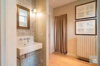 <strong>Indeling:</strong><br /><br />Op het gelijkvloers is er de inkomhal met gastentoilet en vestiaire, aansluitend is er een apart bureel, de leefruimte met zit- en studeerhoek met parketvloeren en de keuken met ontbijthoek. Verder is er nog een dubbele inpandige garage met automatische poorten. <br /><br />De verdieping is ingericht met nachthal, 4 slaapkamers met elk een eigen badkamer en een 5de slaapkamer, momenteel in gebruik als zitkamer. <br /><br />De oostelijke tuin is volledig omheind en aangelegd, voorzien van automatische poort, overdekt terras en een zonneterras.<br /><br /><br /><strong>Afwerking:</strong><br /><br />De keuken is luxueus ingericht met een natuurstenen werkblad, een kookplaat met afzuigkap, oven, vaatwasser en dubbele spoelbak. <br /><br />De badkamer bij de masterbedroom is voorzien van duo ligbad, inloopdouche, dubbele wastafel geïntegreerd in het meubel en een toilet. <br />Badkamer 2 is ensuite en ingericht met ligbad met douchekop, enkele wastafel geïntegreerd in het meubel en een toilet. <br />Badkamer 3 is een doucheruimte met enkele wastafel. <br />De 4de badkamer is ingericht met een douche, dubbele wastafel in het meubel en een toilet.