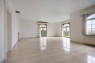 Aan de Kraaistraat 9B in Geetbets vinden we deze imposante Franse villa terug, gebouwd in 2006 met kwalitatieve materialen en een tijdloze architectuur die vandaag de dag nog altijd indruk maakt. De woning is zuidelijk georiënteerd, waardoor de tuin het hele jaar door optimaal van de zon geniet. Een ruime, groene buitenruimte die uitnodigt om te ontspannen of voor de professionele gebruiker, als aangename omgeving voor patiënten en bezoekers.<br /><br />Wie binnenstapt, wordt meteen getroffen door de kwaliteit en de schaal van dit pand. De inkomhal van 17m² zet meteen de toon: representatief, rustig en ruim genoeg om als professionele ontvangst- of wachtruimte in te richten, een troef die in de zorgsector of bij een vrij beroep zelden zo vanzelfsprekend aanwezig is. Aansluitend bevindt zich een uitzonderlijke leefruimte van 60m², die alle kanten opgaat: een royale gezinsruimte, een ruimte voor groepsconsultaties of therapiesessies, een representatieve vergader- of ontvangstruimte, de indeling bepaalt u zelf. De zeer ruime keuken met bijkeuken, de slaapkamer en de volwaardige badkamer op het gelijkvloers completeren een niveau dat perfect autonoom kan functioneren, volledig los van de verdieping.<br /><br />Op de eerste verdieping bevinden zich vijf volledig afgewerkte kamers, elk veelzijdig inzetbaar als slaapkamer, bureau, praktijkruimte of behandelkamer. Eén van de kamers is voorzien van leidingen voor een tweede badkamer. Wat dit niveau werkelijk onderscheidt, is de toegankelijkheid: via een vaste trap vanuit de garage is de verdieping volledig onafhankelijk bereikbaar, zonder enige doorgang over het gelijkvloers. Twee gescheiden ingangen, twee volledig autonome niveaus: de basis voor een dubbele wooneenheid, een praktijk met privéwoning of een groepspraktijk met aparte woonst ligt hier klaar, mits de nodige vergunningen. Aanvullend zijn er nog twee ruime bergzolders, eveneens voorzien van elektriciteit en een betonnen chape, ideaal als technische ruimte, archief of opslag. De woning is bovendien volledig onderkelderd met een kruipkelder over de gehele footprint. Gebouwd in 2006 betekent: geen asbestproblematiek, een degelijke constructie en een EPC-label C dat realistisch en beheersbaar is.<br /><br />Dit pand opent ook een piste die steeds meer families bewust overwegen: de kangoeroe-woning. Ouders en kinderen verkopen elk hun huidige woning, bundelen de opbrengst en stappen samen in één aankoop, maar wonen volledig onafhankelijk van elkaar. Gelijkvloers voor de ene generatie, eerste verdieping met eigen ingang voor de andere. Elke entiteit heeft zijn eigen leefruimte, keuken, badkamer en toegang. Geen compromis op privacy, wel de nabijheid die een zorgzame familieband verdient. Wie twee afzonderlijke woningen op de huidige markt wil kopen voor dit totaalbudget, zal snel merken dat €599.000 voor dit volume en deze kwaliteit een uitzonderlijke opportuniteit is die zich niet twee keer aandient.<br /><br />Of u nu droomt van een woon-werkvilla, een praktijk met privéwoning, een kangoeroe-formule of een investering in twee autonome entiteiten. Dit pand biedt de schaal, de infrastructuur en de flexibiliteit om elk van die verhalen waar te maken. Nieuwbouw met deze kwaliteit en dit volume realiseren voor €599.000 is vandaag simpelweg niet meer mogelijk.