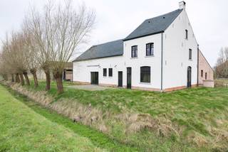 Deze eigendom ligt in een doodlopende straat omgeven door velden, rust en privacy. <br /><br />De hoeve is voorbestemd voor landbouw of para-agrarische activiteiten, bevat een stal dewelke momenteel is ingericht met 17 paardenboxen. Verder is er een binnenpiste en buitenpiste (30m x 60m) aanwezig. De overige loodsen zijn voorzien voor opslag. <br />Achteraan bevinden zich de omheinde weides. <br /><br />De woning omvat op het gelijkvloers een open keuken met eethoek en een authentieke leefruimte met hoge plafonds. Op het gelijkvloers is er ook een apart toilet en badkamer voorzien van dubbele lavabo en een douche-bad. <br /><br />Op de eerste verdieping zijn er 2 tot 3 slaapkamers en is er toegang tot de zolder, deze is nog perfect in te richten als masterbedroom. Aanpalend aan de woning bevindt zich een bijgebouw (vergund als stallen), deze werd recent volledig gerenoveerd tot kantoor met berging en sanitaire blok. Deze woning is voorzien van pelletkachels.<br /><br />Veelzijdige eigendom voor de professionele paardenfokker of een andere (para) agrarische activiteit!