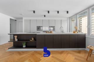 Exclusief en Luxueus Appartement nabij het Strand – Mariakerke, Oostende<br /><br />Voor wie verlangt naar een verfijnde en luxueuze leefomgeving, biedt dit exclusieve appartement nabij het strand van Mariakerke een ongeëvenaarde ervaring. Dit ruime en stijlvol gerenoveerde verblijf (2024) is gevestigd in een recent gebouw en is volledig instapklaar, met een energielabel B dat zorg draagt voor een energiezuinig verblijf.<br /><br />Indeling &amp; Kenmerken:<br />Met een royale oppervlakte van 162 m² geniet u van een indeling die functionaliteit en elegantie combineert. Bij binnenkomst komt u in een statige inkomhal die leidt naar een indrukwekkende, lichtrijke woonkamer met een prachtig visgraatparket die de ruimte grandeur geeft. De open keuken is voorzien van hoogwaardige, geïntegreerde apparatuur (gaggenau) en biedt een overvloed aan kastruimte – ideaal voor culinaire fijnproevers.<br /><br />Dit appartement omvat drie ruime slaapkamers, waaronder een verfijnde master suite met een en-suite badkamer voorzien van een luxueus ligbad en een stijlvol dubbel lavabomeubel. Voor uw comfort is er een tweede badkamer met een wellnessdouche uitgerust met geavanceerde functies zoals stoom, muziek, aroma, en massagejets. Verder biedt het appartement een praktische berging met aansluiting voor wasmachine en een apart toilet.<br /><br />Buitenzijde:<br />Het indrukwekkende terras van maar liefst 66 m² omringt het appartement en biedt adembenemende uitzichten op de zee en de wellington golfbaan van Oostende. Een plek om volledig tot rust te komen terwijl u geniet van de serene omgeving.<br /><br />Extra Faciliteiten:<br />Het gebouw is voorzien van een beveiligde fietsenberging, en er bestaat de mogelijkheid om een garagebox aan te kopen, wat extra comfort en gemak toevoegt.<br /><br />Ligging:<br />Dit exclusieve appartement bevindt zich in Mariakerke, een rustige en prestigieuze wijk in Oostende. Geniet van de nabijheid van het strand, de Wellington Golf, het zwembad en tal van winkels, supermarkten, en openbaar vervoer. De ligging is ideaal voor wie de balans zoekt tussen ontspanning en stadscomfort.