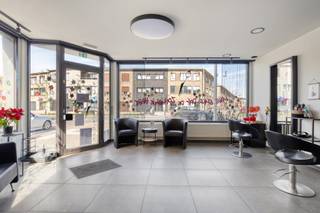 Dit vergund appartementsgebouw met 8 appartementen en een handelszaak ligt op één van de belangrijkste toegangswegen tot de binnenstad en op wandelafstand van het station en het centrum. Het gelijkvloers wordt deels ingenomen door een handelszaak (kapper). Naast de handelszaak telt het gelijkvloers nog twee appartementen met elk één slaapkamer en een kleine buitenruimte. De eerste en tweede verdieping tellen elk drie appartementen waarvan twee met twee slaapkamers en één met één slaapkamer. Deze laatste appartementen hebben ook een terras. Gebouw is algemeen in goede staat en is momenteel volledig verhuurd. Totale jaarlijkse netto huuropbrengst bedraagt ca. 83.000 euro. Alle energiemeters zijn privatief en elk appartement beschikt over een ondergrondse privatieve kelderberging. Mogelijkheid bestaat om - mits vergunning - via optopping uit te breiden. Electriciteit conform, geen energetische renovatieplicht.