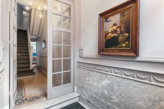 Locatie: Dit herenhuis staat te koop in de Coebergerstraat 20 in de populaire Markgravewijk in 2018 Antwerpen. Het is gelegen in een rustige en residentiële buurt, maar toch op wandelafstand van tal van hippe restaurants, cafés en het Hof Van Leysen park. Ook openbaar vervoer en belangrijke invalswegen zijn vlot bereikbaar.<br /><br />Beschrijving: Ontdek dit karaktervol en instapklaar herenhuis vol authentieke elementen. Via de statige inkomhal met charmante glazen deuren en authentieke mozaïekvloer krijgt u toegang tot het ruim en open leefgedeelte. Hier zorgen de visgraatparket, grote raampartijen en een ingebouwde elektrische haard voor een warme en gezellige sfeer. Achteraan bevindt zich de open en volledig ingerichte keuken, die dankzij de grote lichtkoepels geniet van overvloedig daglicht en een mooie connectie met de tuin.<br /><br />Op de tussenverdieping bevindt zich een inloopdressing die doorloopt naar de royale badkamer. De eerste verdieping biedt twee ruime slaapkamers met hoge plafonds en parketvloeren. De masterbedroom aan de voorzijde geniet van een prachtige lichtinval dankzij de karaktervolle erker.<br /><br />Op de tweede tussenverdieping bevindt zich nog een slaapkamer met badkamer. Het bovenste verdiep is ingericht als studio met volwaardige keuken en zonnig dakterras.<br /><br />Bijzonderheden:<br />- Dakisolatie aanwezig + 16 zonnepanelen<br />- Ruime kelder met wasplaats