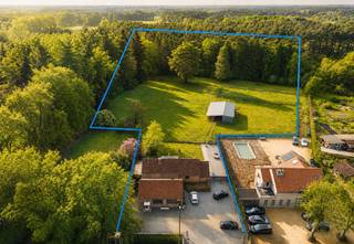 <p><strong>GELIJKVLOERS<br /></strong><strong>Inkomhal 18m²</strong> op kerkdal met vestiairekast, gastentoilet en handenwasser.<br /><strong>Woonkamer 42m²</strong> op kerkdal via grote schuifraam toegang tot terras.<br /><strong>Eetkamer 15m²</strong> op kerkdal met zicht op weilanden.<br /><strong>Keuken in eik 23m²</strong> op kerkdal, voorzien van inductiekookplaat, koelkast, vaatwasser, combi-oven, dampkap, dubbele spoelbak in arduin, kookeiland en ontbijthoek.<br />Aansluitend aan de keuken <strong>berging/mudroom 15m²</strong> op platines met uitgietbak in arduin en toilet met handenwasser.<br /><strong>Wasplaats 6m²</strong> op kerkdal met ingebouwde kasten en aansluiting voor wasmachine en droogkast.<br /><strong>Slaapkamer 19m²</strong> op kerkdal met deur naar terras.<br /><strong>Dressing 11m²</strong> op kerkdal.<br /><strong>Badkamer 8m²</strong> op met ligbad, inloopdouche en enkele lavabo.<br /><strong><br />Kelder 111m².</strong></p>
<p><strong>Terras 40m²</strong> op platines.<br /><strong>2de terras 50m²</strong> op blauwe hardsteen.</p>
<p>Verzorgde tuin met tuinverlichting en geboorde waterput.<br /><strong>Weiland met 5 stallen +- 110m².</strong></p>
<p><strong>Zolder 40m²</strong> op beton, mogelijkheid tot het maken van 2 slaapkamers.<br /><strong>Carport </strong>voor 1 wagen.</p>
<p><strong>PRAKTIJKRUIMTE/UITBREIDING WONING</strong><br />Deze ruimte van 72m² op steenparket is ideaal als praktijkruimte aan huis of om de huidige gezinswoning uit te breiden naar meerdere slaapkamers.<br />Momenteel heeft de huidige woning 1 slaapkamer.</p>
<p><strong>BIJZONDERHEDEN<br /></strong>De vermelde “bewoonbare oppervlakte” is gebaseerd op de “bruikbare vloeroppervlakte” zoals vermeld in het EPC.Verwarming op stookolie, dubbele beglazing, alarm, sensoren, tuinverlichting, geboorde waterput, volledige isolatie.</p>
<p><strong>POSITIEVE PUNTEN<br /></strong>Instapklaar<br />Ruime kelder<br />Zicht op weilanden<br />Duurzaam gebouwd<br />Gelijkvloerse woning<br />Woning met praktijkruimte<br />Zuidwest georiënteerde tuin<br />Ideaal voor paardenliefhebbers of wonen/werken</p>