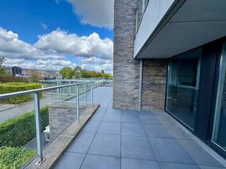 TE KOOP – ZWIJNAARDE | Stijlvol, energiezuinig én instapklaar. Welkom in dit recent en luxueus afgewerkt appartement in Zwijnaarde, een plek waar comfort, rust en een uitstekende bereikbaarheid harmonieus samenkomen. Dankzij de grote raampartijen baadt de leefruimte in het licht en geniet u vanuit de eetplaats rechtstreeks van het ruime, zonnige terras met een prachtig uitzicht op het omliggende groen. De open keuken sluit hier naadloos op aan en wordt praktisch aangevuld met een handige berging. Verder beschikt het appartement over twee aangename slaapkamers, een moderne badkamer en een apart toilet.<br />Het appartement is niet alleen stijlvol, maar ook bijzonder energiezuinig dankzij het EPC-label A. Een ondergrondse kelderberging is inbegrepen, en wie dat wenst kan bovendien een private parkeerplaats aankopen.<br />De ligging in een rustige, groene buurt van Zwijnaarde maakt dit appartement extra aantrekkelijk. U woont er op een boogscheut van Gent en geniet van een vlotte aansluiting op de E40 en de R4, terwijl winkels, scholen en openbaar vervoer in de nabije omgeving liggen.<br />Dit appartement biedt een zeldzame combinatie van hedendaagse afwerking, een schitterend terras, energiezuinig wooncomfort en een topligging. Een unieke kans voor wie stijlvol en zorgeloos wil wonen.