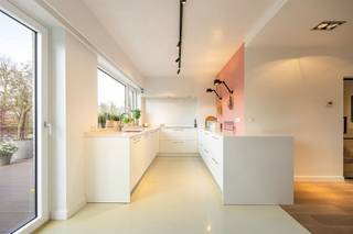 <p><span>Wonen op Linkeroever, op wandelafstand van het Sint-Annastrand en de jachthaven? In deze rustige, groene woonwijk vind je deze instapklare bel-etage. Met haar hoogwaardige afwerking, royale volumes en zonnige tuin is dit een woning waar comfort en stijl hand in hand gaan.</span></p><p><span> </span></p><p><span>Ruimte, licht en mogelijkheden</span></p><p><span>Binnenkomen doe je via een ruime inkomhal met een glazen designdeur die meteen zorgt voor een open en lichtrijk gevoel. De ingemaakte kasten houden alles netjes uit het zicht, terwijl de trap je uitnodigt om verder te ontdekken.  Op het gelijkvloers zit een enorme troef: een inpandige garage van ca. 38,5 m² met zeeën van opbergruimte. Aansluitend ligt een polyvalente ruimte die perfect kan dienen als hobbyruimte, praktijk, speelkamer of zelfs thuiskantoor. Dankzij de grote raampartijen en de directe connectie met de tuin voelt deze ruimte allesbehalve secundair aan.  Ook een aparte bureauruimte maakt thuiswerken hier bijzonder aangenaam.</span></p><p><span> </span></p><p><span>Leven op niveau</span></p><p><span>De eerste verdieping is zonder twijfel het hart van de woning. Hier vloeien licht, ruimte en comfort moeiteloos in elkaar over. De leefruimte baadt in het daglicht dankzij de grote ramen en voelt extra warm aan door de mooie parketvloer en de strakke afwerking. Aansluitend ligt de open keuken, een echte eyecatcher met haar minimalistische witte design, composieten werkblad en kwalitatieve toestellen. Hier kook je met zicht op buiten én in verbinding met je gasten.</span></p><p><span>Vanuit de keuken stap je zo het terras op – perfect voor een aperitiefje in de zon – met een open zicht op de tuin.</span></p><p><span> </span></p><p><span>Groen genieten, elke dag opnieuw</span></p><p><span>Achteraan wacht een verrassend mooie, onderhoudsvriendelijke tuin. Een combinatie van groen, terrassen en gezellige hoekjes zorgt ervoor dat je hier op elk moment van de dag een fijne plek vindt. De vijver en volwassen beplanting geven de tuin een unieke, rustgevende sfeer.  Dit is zo’n buitenruimte waar je meteen wil blijven hangen, van eerste koffie tot lange zomeravonden.</span></p><p><span> </span></p><p><span>Slaapverdieping met hotelgevoel</span></p><p><span>Op de tweede verdieping bevinden zich drie volwaardige slaapkamers, allemaal lichtrijk en netjes afgewerkt. Ideaal voor een gezin, maar evengoed perfect in te richten als dressing of bureau.  De badkamer is ruim en stijlvol, met ligbad, inloopdouche en dubbele wastafel – strak, licht en helemaal van nu. Daarnaast is er nog een tweede douchekamer, wat het comfort alleen maar verhoogt.</span></p><p><span>Nog een trapje hoger vind je een gezellige zolderruimte met karaktervolle balken en veel lichtinval. Ideaal als extra slaapkamer, hobbyruimte of rustige werkplek.</span></p><p><span> </span></p><p><span>Rustig wonen, vlak bij de stad</span></p><p><span>Hier woon je in een kalme, residentiële buurt op Linkeroever, met het strand, de jachthaven en groene wandelplekken op wandelafstand. Ook voor de sportievelingen situeert zich een heleboel om de hoek: Een tennisclub, een manege en een openluchtzwembad vind je dichtbij. Tegelijk ben je via de Sint-Annatunnel of het openbaar vervoer zo in het centrum van Antwerpen. Denk aan de gratis veerboot en waterbus je die zo aan de andere kant van het water brengen. Rust en bereikbaarheid gaan hier perfect samen.</span></p><p><span> </span></p>