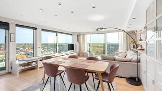 <span>Uitzonderlijke penthouse gelegen op de Zeedijk aan het Van Bunnenplein met panoramische zichten op land en zee en mooi zonneterras achteraan.</span><br /><br /><span>Indeling: inkom met videofoon, vestiaire, gastentoilet en berging.</span><br /><span>De ruime woonkamer met parketvloer biedt een adembenemend zicht op zee en over gans Knokke en leidt naar een royaal terras. De open keuken is voorzien van alle toestellen.</span><br /><span>Masterbedroom met ingemaakte kasten en ensuite badkamer uitgevend op het zuidgericht terras. Slaapkamer 2 met stapelbed, enkel bed en douchekamer, mogelijkheid om stapelbedden weg te doen en te vervangen door een dubbel bed.</span><br /><span>Kelder &amp; fietsenberging in de residentie.</span><br /><br /><span>Mogelijkheid tot aankoop van een dubbele gesloten garagebox in de residentie Grand Hotel.</span><br /><br /><span>Een bezoek is sterk aanbevolen om de volledige charme van dit appartement te ervaren!</span>