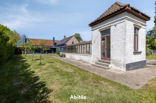 In het unieke Assels-gebied, vlak bij de Blaarmeersen, bevindt zich deze karaktervolle hoeve op een uitzonderlijk domein van maar liefst <strong>6.546 m²</strong>. Deze historische eigendom, met oorsprong in het begin van de 19de eeuw, combineert ruimte, privacy en karakter met een verrassend vlotte verbinding naar Gent en de R4.<br /><br />Deze hoeve beschikt over een bijzonder ruime en veelzijdige indeling. Het residentiële gedeelte omvat op het gelijkvloers onder meer een woonkamer, eigen keuken, badkamer en dressing. Aansluitend bevinden zich verschillende praktische ruimtes, waaronder garages, een prachtige serre en berging.<br /><br />Op de verdieping bevinden zich <strong>5 slaapkamers</strong>, een tweede badkamer en een omvangrijke bijkomende ruimte die vandaag als opslag wordt gebruikt en, afhankelijk van de gewenste invulling en de nodige vergunningen, bijkomende mogelijkheden biedt.<br /><br />Een afzonderlijk gedeelte van het gelijkvloers is vandaag ingericht als <strong>restaurant</strong>, met 2 restaurantzalen, keuken, inkom en sanitair. Deze bestaande infrastructuur geeft de eigendom een extra dimensie. Ze biedt interessante mogelijkheden voor wie wonen en werken wil combineren, maar laat eveneens ruimte voor een andere toekomstige invulling, uiteraard rekening houdend met de geldende voorschriften en eventuele vergunningsvereisten.<br /><br /><strong>Het domein zelf is een van de absolute blikvangers van deze eigendom.</strong> De hoeve wordt omgeven door een uitgestrekt groen geheel met park- en bosgedeelte en verschillende buitenzones die zorgen voor een bijzonder gevoel van ruimte en privacy.<br /><br />Ook de ruime parking voor circa <strong>50 wagens</strong> vormt een interessante bijkomende troef. De mogelijkheid om hier elektrische laadinfrastructuur te voorzien werd reeds afgetoetst met een gespecialiseerde leverancier. Hierdoor ontstaat, naast de praktische parkeerfunctie, ook potentieel om deze oppervlakte economisch te valoriseren.<br /><br />De combinatie van wonen, ruimte, groen en bestaande infrastructuur maakt uiteenlopende toekomstscenario's mogelijk: een royale gezinswoning, wonen met een vrij beroep of zelfstandige activiteit, een combinatie van wonen en werken, of het behoud van de bestaande horecafunctie. Uiteraard steeds rekening houdend met de geldende stedenbouwkundige voorschriften en eventuele vergunningsvereisten.<br /><br /><strong>Laat u verder begeleiden in dit bijzondere verhaal. Contacteer Jan voor meer informatie of een bezoek:</strong><br />📞 Jan: 0475 58 00 38<br />📧 jan@abitos.be