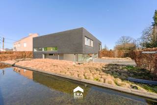 <p>Moderne en energiezuinige villa met hoogwaardige afwerking, voorzien van een epoxyvloer, Neff-keukentoestellen, Noha-handgrepen, zonnepanelen (9.500 Wp) en vloerverwarming (warmte en koelen) enz.</p><p><br /></p><p>Geniet van de prachtig aangelegde tuin met 2 zonnige terrassen, ideaal om na het werk volledig te ontspannen. De zwemvijver en volledig uitgerust poolhouse zorgen voor het ultieme vakantiegevoel in eigen tuin.</p><p><br /></p><p><u>INDELING:</u></p><p><strong>- Kelder verdiep (70 m2):</strong> Garage met sectionale poort, technische ruimte en grote berging.</p><p><strong>- Gelijkvloers:</strong> Inkomhal, toilet en vestiaire. Afzonderlijk toegankelijke bureauruimte die kan worden gebruikt voor een zelfstandige activiteit of vrij beroep. Zeer lichtrijke open keuken met zeer veel opbergruimte, aparte berging/wasplaats en aansluitend de woonkamer met zit-en eetplaats. Patio in het midden en grote raampartijen met zicht op de tuin.</p><p><strong>- 1ste verdiep: </strong>Nachthal, 2 slaapkamers, master bedroom met bureau en dressing en badkamer met ligbad, dubbele inloopdouche en dubbele lavabo.</p><p><strong>- Exterieur: </strong>Aangelegde tuin met diverse perken, 2 zonnige terrassen en natuurlijke gefilterde zwemvijver. Oprit met toegangspoort en carport voor 2 auto's.</p><p><strong>- Poolhouse: </strong>Volledig geïnstalleerd met oa. keuken, inloopdouche, toilet en tuinberging.</p><p><br /></p><p><u>PLUSPUNTEN:</u></p><p>+ Energiezuinig (A-Label)</p><p>+ Combineer wonen en werk</p><p>+ Zonnepanelen met groenestroomcertificaten (9.500 WP)</p><p>+ Poolhouse en zwemvijver</p><p>+ Totale oppervlakte van 1.237 m2</p><p>+ Airco's, zonnescreens, ventilatie D,</p><p>+ ...</p><p>Bel vandaag nog voor meer informatie of een bezoek!</p>