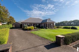 <p><strong>Aan de groene rand van Poppel bevindt zich deze uitstekend onderhouden villa op een prachtig perceel van ca. 2.000 m². De woning combineert een aangenaam wooncomfort met bijzonder veel ruimte en geniet bovendien van een prachtig open zicht over de achterliggende weilanden. Tot de grote troeven behoren onder meer de volledig vernieuwde, hoogwaardig afgewerkte keuken, de lichtrijke leefruimtes, 3 ruime slaapkamers, een grote zolderverdieping en de dubbele garage met atelier. De woning beschikt over een EPC-label F.</strong></p>
<p><span>Via de ruime inkomhal bereikt u enerzijds het leefgedeelte en anderzijds de slaapvertrekken. De woonkamer geniet dankzij de vele raampartijen van bijzonder veel natuurlijk daglicht. De gezellige zithoek met houtkachel kijkt uit naar de voorzijde van de woning, terwijl u vanuit de aangrenzende tuinkamer geniet van een prachtig vergezicht over de weilanden. Dankzij de grote opengaande raampartijen vormt deze ruimte een heerlijke verbinding tussen binnen en buiten.</span></p>
<p><span>Centraal in de leefruimte bevindt zich de eetkamer, met voldoende plaats om uitgebreid te tafelen met familie en vrienden. Aansluitend ligt de volledig vernieuwde keuken, uitgevoerd in hoogwaardige materialen met massieve kastdeuren, een natuurstenen werkblad, kwalitatieve Miele-toestellen, dubbele spoelbak en bijzonder veel opbergruimte. De keuken werd uitgebreid met een lichtrijke eet- en tuinkamer aan de zuidoostzijde, vanwaar u rechtstreeks toegang heeft tot het terras en de tuin.</span></p>
<p><span>Verder beschikt de keuken over een praktische voorraadkast. De ruime bijkeuken/wasplaats biedt plaats voor wasmachine, droogkast en strijkruimte en heeft eveneens rechtstreeks toegang tot het terras. Ook de verwarmingsinstallatie bevindt zich hier, samen met een extra wastafel.</span></p>
<p><span>De nachthal geeft toegang tot drie volwaardige slaapkamers, een afzonderlijk toilet en de badkamer, uitgerust met ligbad, douche, wastafel en maatwerkkasten. Via de bijkeuken bereikt u bovendien de ruime zolderverdieping, die nog volledig naar eigen behoefte kan worden ingericht, bijvoorbeeld als bijkomende slaapkamers, hobbyruimte of bureau.</span></p>
<p><span>Een absolute meerwaarde is de bijzonder ruime dubbele garage met aansluitend atelier. Hier is niet alleen plaats voor twee wagens, maar ook voor een volwaardige werkplaats, hobbyruimte of extra stockage.</span></p>
<p><span>Ook buiten is het heerlijk vertoeven. Dankzij de uitstekende oriëntatie geniet de tuin volop van de zon. Rond het terras bevindt zich een verzorgde siertuin, terwijl het achterste gedeelte van het ruime perceel tal van mogelijkheden biedt voor onder meer een moestuin, kippenren, houtopslag of andere hobby’s.</span></p>
<p><strong><span>Een bijzonder complete eigendom voor wie op zoek is naar ruimte, rust, een kwalitatieve afwerking en een groen uitzicht op een mooie locatie in Poppel.<br /><br /></span></strong>Stedenbouwkundige inlichtingen in aanvraag<strong><span><br /></span></strong></p>