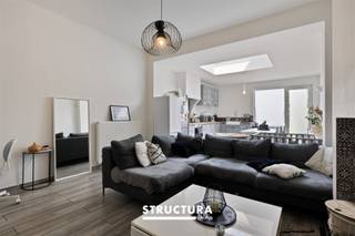 Welkom in deze charmante woning gelegen in het hart van Aalst. Met een bewoonbare oppervlakte van 115m² en een perceeloppervlakte van 140m², biedt deze goed onderhouden woning alles wat u nodig heeft voor comfortabel wonen. Bij binnenkomst wordt u verwelkomd door een lichte inkomhal die leidt naar de ruime leefruimte. De open indeling van de woonkamer en eetkamer creëert een gezellige en uitnodigende sfeer. Dankzij het grote dakraam baadt de ruimte in natuurlijk licht, wat een warme ambiance versterkt. De moderne keuken is volledig uitgerust en voorzien van stijlvolle kasten en werkbladen, ideaal voor de kookliefhebber. Grote openslaande deuren leiden naar de charmante achtertuin, waar u kunt ontspannen en genieten van de buitenlucht. De tuin biedt voldoende ruimte voor buiten dineren en tuinieren. De eerste verdieping herbergt een comfortabele slaapkamer en de badkamer, stijlvol en praktisch ingericht, met een stijlvolle wastafel en een moderne inloopdouche. Hier kunt u heerlijk ontspannen en genieten van uw moment van rust. De overige kamers op de 2de verdieping zijn flexibel inzetbaar als kinder-, logeer-, of bureauruimte. Hoewel de woning geen garage heeft, is er voldoende parkeergelegenheid in de directe omgeving. Met zijn centrale ligging geniet u van de nabijheid van winkels, scholen en openbaar vervoer, waardoor deze woning ideaal is voor gezinnen en jonge professionals. Mis deze kans niet om deze prachtige woning in Aalst te bezichtigen. Uw nieuwe thuis wacht op u!