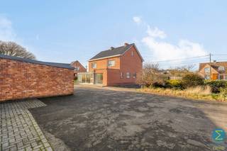 Deze landelijk gelegen ruime woning bevindt zich op een perceel van 1.943m² met een vergund bijgebouw van ca. 220m².<br /><br />De centrale inkomtraphal geeft rechts toegang tot de woonkamer en een bureauruimte aan de linkerzijde. Aansluitend bij de living treft men de ruime keuken met eethoek, toegang tot de kelder en grote veranda, alsook een sas met apart toilet en de badkamer met inloopdouche en wastafelmeubel.<br />Op de verdieping bevinden zich de vier royale slaapkamers en leidt een vast trap naar de zolder, dewelke de mogelijkheid biedt tot het inrichten van bijkomende kamers.<br /><br />Voor wie nood heeft aan een werkruimte, atelier of opslagruimte, voorziet dit eigendom achteraan een groot bijgebouw met inpandige garage, alsook voldoende parkeergelegenheid.<br /><br />Tevens is er een mogelijkheid om het geheel op te splitsen, zodat de woning kan behouden blijven op een perceel van 1.115m² en aan de linkerzijde een bouwkavel van 898m² kan gecreëerd worden (verkavelingsvergunning).<br /><br />Specificaties:<br />- Rustige, landelijke ligging<br />- Schrijnwerk: aluminium en hout<br />- Rolluiken rondom<br />- EPC: 596 kWh/ (m² jaar) - F-label<br />- Multifunctioneel bijgebouw