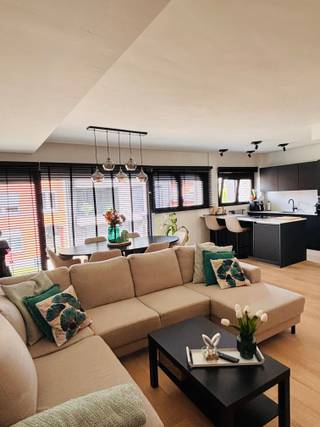 Dit lichtrijke en moderne appartement op de eerste verdieping werd in 2023 volledig gerenoveerd met oog voor energiezuinigheid en comfort. Dankzij de centrale ligging bevindt u zich op korte afstand van het gemeentecentrum, de E313, scholen en openbaar vervoer.<br /><br />De woning beschikt over een ruime leefruimte met open, volledig uitgeruste keuken. Deze is voorzien van een vaatwasser, combi-oven en een inductiekookplaat met geïntegreerd afzuigsysteem. Verder omvat het appartement drie volwaardige slaapkamers, een stijlvolle badkamer met ruime inloopdouche en dubbele lavabo, een apart toilet, een praktische was-/bergruimte en een extra bureaukamer.<br /><br />Extra troeven zijn de elektrische rolluiken achteraan en de op maat gemaakte lamellen vooraan. De vloerverwarming en het ventilatiesysteem in de volledige woning dragen bij aan een optimaal wooncomfort.<br /><br />De zonnige tuin van 120 m2 biedt een aangename buitenruimte waar u vrijwel de hele dag van de zon kunt genieten. Achteraan de tuin heeft u directe toegang tot een ruime garage van 22 m2, voorzien van aansluiting voor een elektrische laadpaal.<br /><br />Tot slot beschikt het appartement over een gunstig EPC-label B, is het asbestvrij en heeft het een bewoonbare oppervlakte van 115 m².<br />