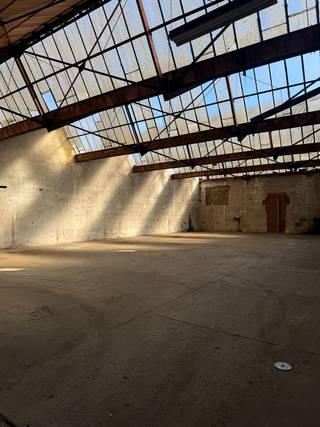 Lichtrijk en droog magazijn met grote inrijpoort en parking 14 x 25 m. 