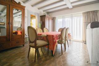 Rustig gelegen gelijkvloerse woning met 3 slaapkamers op 973 m². Inkomhal.Woonkamer van 34 m² op stenen vloer met houtkachel als...