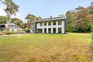 On a beautiful plot of approximately 3,533 m², this spacious villa with about 394 m² of living space and a separate multifunctional area is situated. The property combines generous living spaces, abundant light, and a strong connection to the garden, offering numerous possibilities for practice, office space, freelance work, or a Kangoeroe home (multi-generational living).<br /><br />Large windows and warm materials contribute to a pleasant living experience, while the mature planting around the property ensures tranquility and privacy.<br /><br />Ground Floor – Living Area:<br />Entering through the spacious entrance hall with a characterful open staircase, we reach the living area. The living space forms a generous and open whole with various seating and dining areas, an integrated fireplace, and custom-built features. Large windows allow for an abundance of natural light and provide a beautiful view of the surrounding garden. Adjacent to it is the spacious dining room with direct access to the terrace and garden. The separate kitchen offers ample work and storage space and also enjoys views of the greenery.<br /><br />Ground Floor – Practice/Multifunctional Area:<br />On the other side of the house, there is a separate multifunctional area with its own entrance. This includes a spacious multipurpose room, a private kitchen, a bathroom with a shower, and a separate sleeping or living area. Thanks to its own layout and the ability to use this area functionally independent of the main volume, it is ideally suited for a practice, office, freelance work, guest accommodation, or other multifunctional purposes, depending on the permitted use.<br /><br />First Floor – Living Area:<br />The first floor of the main volume comprises several spacious bedrooms, including a generous master bedroom. Additionally, there are multiple bathrooms, including one with a bathtub and sink, and a second bathroom with a shower and double sink. There is also a sauna room with a shower and sink. An additional office or multipurpose space provides extra flexibility. This floor also benefits from pleasant light and views of the garden.<br /><br />First Floor – Multifunctional Area:<br />Via a separate staircase, an additional bedroom is accessible above the multifunctional area. This room is located under the sloping roof and features two skylights and built-in storage space. This allows the multifunctional area to operate even more autonomously if desired, for example, as guest accommodation or additional living space.<br /><br />Second Floor – Living Area:<br />The second floor includes two spacious bedrooms under the roof. Thanks to two large skylights and additional facade windows, this floor enjoys plenty of natural light. Adjacent to it is a private bathroom, making this floor perfectly functional as a separate master suite, guest suite, or teen suite.<br /><br />**Garden and Terraces:**<br />The property is set on an exceptionally green plot of approximately 3,533 m². The garden mainly consists of a spacious lawn and is bordered by mature trees, rhododendrons, and other greenery. Various terraces connect directly to the living areas, creating a strong connection between indoors and outdoors. The spacious driveway accommodates several cars, and the green surroundings provide a pronounced sense of peace and privacy.<br /><br />Special Features:<br />- 8 bedrooms or office/multipurpose spaces<br />- 5 bathrooms<br />- Possibility of combining living and working<br />- EPC label B – 142 kWh/m²<br />- 15 solar panels with a total capacity of 7.5 KW and a home battery<br />- High-efficiency triple glazing