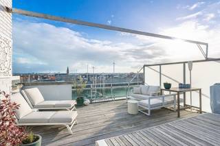 Schitterend dakappartement met één slaapkamer en extra grote zonneterrassen aan de jachthaven van Zeebrugge. De ganse dag genieten in de zon en van het uitzicht over de boten in de jachthaven. Vlotte verbinding met de tram/auto/fiets naar Knokke-Heist en Blankenberge.<br /><br />Indeling: inkomhal met ingebouwde vestiairekast, een gezellige leefruimte met directe toegang tot het ruim zonneterras. Verder een open keuken die voorzien is van alle toestellen, één grote slaapkamer, een ingerichte badkamer met lavabo en douche, een gastentoilet en een berging met aansluiting voor wasmachine en droogkast.<br /><br />De ramen werden recent vernieuwd naar hoogrendementsglas en er is een blanco elektriciteitskeuring. De mooie terrassen zijn uniek. <br /><br />Na de isolatie van het gemeenschappelijke dak vervalt de renovatieplicht. De kosten hiervoor worden verdeeld onder alle mede-eigenaars van de residentie. De renovatie werd al meermaals besproken met de VME. Na het isoleren van het dak bekomt het pand een label C (mits plaatsen 12cm PUR isolatie).<br /><br />Op het gelijkvloers een gemeenschappelijke fietsenberging en afvallokaal. Er is de mogelijkheid om in het gebouw een gemakkelijk toegankelijke dubbele garagebox aan te kopen.<br /><br />Bezoek sterk aanbevolen!<br /><br />Bezoeken? Graag na afspraak met Willem Cauwels op 050/89.27.70