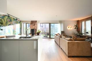 Dit nieuwbouwappartement maakt deel uit van de succesvolle ontwikkeling LUX, een groen woonpark in de zuidrand van de stad. Een ligging die het beste van beide werelden combineert: de rust van de natuur en de nabijheid van het stadsleven met vlotte ontsluiting naar de E40, E17, R4 en R40. Op slechts een steenworp van de Schelde kunt u genieten van wandelingen en de prachtige natuur. Langs het water is het heerlijk fietsen naar het historische centrum, het UZ Gent en het station Gent-Sint-Pieters, allen op minder dan 10 minuten fietsen. <br /><br />De schakelwoning met private inkomdeur heeft een bewoonbare oppervlakte van liefst 141 m² en biedt daarnaast een tuin van 126 m². De indeling is als volgt: via de inkomhal bereikt men de zonnige eet- en leefruimte met een open keuken, voorzien van een ruim kookeiland en twee praktische bergingen. De grote raampartij met schuifraam biedt een rechtstreekse toegang tot het aanpalende terras en tuin met een perfecte zuidwestelijke oriëntatie. De drie slaapkamers bereikt men via de nachthal. Daarnaast vindt men er ook een afzonderlijk toilet en twee badkamers, één met een douche en de andere met een ligbad en dressing. Tot slot bevindt er zich rechtover de tuin een privatieve (fietsen)berging die bij deze woning hoort. Een ondergrondse autostaanplaats met laadpaal kan optioneel aangekocht worden.<br /><br />In de kelderverdieping bevindt zich een gemeenschappelijke fietsenstalling en als kers op de taart beschikt de residentie over een riant, gemeenschappelijk dakterras met panoramisch zicht over Gent.<br /><br />Het appartement is uitgerust met vloerverwarming voor een optimaal ruimtegebruik en een ventilatiesysteem type D, wat zorgt voor een gezond en comfortabel binnenklimaat én een lage energiefactuur (EPC A). Bijkomend beschikt het appartement over een stijlvolle parketvloer die warmte en karakter uitstraalt. <br /><br />Bent u op zoek naar een appartement met tuin en drie slaapkamers in Gent? Een afspraak kan via leticia@landbergh.be of bel 09 225 25 24. 