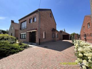 Ontdek deze ruime, open bebouwing gelegen op een zuidgericht perceel van 20a20ca met groene uitzichten over weilanden in een residentiële woonstraat nabij de dorpskern van Onze-Lieve-Vrouw-Lombeek. De vrijstaande gezinswoning beschikt over een bebouwde oppervlakte van maar liefst 344 m² en biedt tal van mogelijkheden voor wie op zoek is naar ruimte en een woning die nog volledig naar eigen smaak kan worden gemoderniseerd. Op de gelijkvloerse verdieping bevindt zich een inkomhal met traphal naar de eerste verdieping. De grote en lichtrijke leefruimte van 35 m² geniet van een aangenaam uitzicht op de tuin en sluit aan op de ingerichte keuken die toegang biedt tot de veranda en provisiekelder. Verder beschikt het gelijkvloers over een apart toilet, een chauffageruimte, enkele aanbouwen die dienen als berging, een inpandige garage met automatische poort die plaats biedt aan 1 wagen en een ruime oprit die zorgt voor extra parkeergelegenheid. Op de eerste verdieping geeft de nachthal toegang tot drie slaapkamers van 20m², 15m² en 11m² en een ingerichte badkamer met ligbad en toilet. De zolder biedt bovendien nog mogelijkheden om extra slaapkamers, een bureau- of hobbyruimte te creëren. De zuidwestgerichte tuin vormt een absolute troef en biedt een vrij uitzicht over de omliggende weilanden. De woning is verder uitgerust met centrale verwarming op mazout en dubbele beglazing. Kortom, een ruime woning met een solide basis, tal van praktische ruimtes en bijzonder veel potentieel. Interesse? Vraag nu meer informatie of maak een afspraak 054/69.68.67.