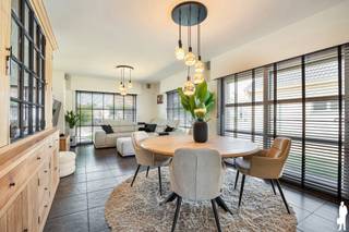 Op zoek naar een instapklare, energiezuinige woning met uitzonderlijk veel ruimte en tal van mogelijkheden? Deze luxueuze open bebouwing op een perceel van 741 m² combineert hedendaags wooncomfort met een rustige, groene ligging en een vlotte verbinding naar de E34. Dankzij de royale bewoonbare oppervlakte en de aparte woonunit biedt deze eigendom heel wat mogelijkheden, zoals een kangoeroewoning, praktijk aan huis, cohousing of een polyvalente ruimte.<br /><br />Indeling<br />Gelijkvloers<br />Bij het betreden van de woning komt de ruime inkomhal meteen uitnodigend over. De lichtrijke leefruimte sluit naadloos aan op de moderne open keuken, uitgerust met kwalitatieve toestellen zoals een stoomoven, oven, vaatwasser en koelkast. Dankzij de vele kastruimtes en het prachtige uitzicht op de tuin vormt deze ruimte het hart van de woning.<br /><br />Verder bevinden zich op het gelijkvloers:<br />- Praktische berging/wasplaats<br />- Gastentoilet<br />- Twee ruime slaapkamers van ca. 15 m² en 14 m²<br />- Recente, stijlvolle badkamer<br /><br />Aansluitend bevindt zich een afzonderlijke ruimte van ongeveer 40 m² die perfect dienst kan doen als woonunit, praktijkruimte, bureau of polyvalente ruimte. In deze ruimte is ook een gastentoilet aanwezig. Er is een rechtstreekse toegang tot de woning, maar ook een aparte ingang. <br /><br />De bovenverdieping beschikt over:<br />- Ruime slaapkamer van ca. 16 m²<br />- Ensuite badkamer<br /><br />De volledig omheinde en onderhoudsvriendelijke tuin vormt een heerlijke plek om in alle rust te genieten. Dankzij de twee terrassen is er op elk moment van de dag een aangename plek in de zon of schaduw. De ruime oprit biedt voldoende parkeergelegenheid en geeft toegang tot de garage van ca. 25 m².<br /><br />Extra troeven<br />- EPC-label B<br />- Zeer energiezuinige woning<br />- Elektrische rolluiken<br />- Nieuwe condensatieketel (2023)<br />- Zonnepanelen<br />- Conforme elektriciteitskeuring<br />- Vier airco's<br /><br />Een veelzijdige en perfect onderhouden woning waar ruimte, comfort en energiezuinigheid hand in hand gaan. Ideaal voor grote gezinnen of voor wie wonen en werken wil combineren op één locatie. Zeker een bezoek waard!