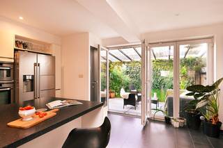 In de populaire Groenenhoek in Berchem bevindt zich deze charmante en verrassend ruime gezinswoning met vier slaapkamers, een grote leefkeuken en een fijne tuin.Het gelijkvloers strekt zich uit van voor- tot achtergevel. Vooraan bevindt zich de gezellige zithoek, gevolgd door de eetkamer en achteraan de royale leefkeuken met groot kookeiland. Dankzij de lichtkoepel en grote raampartijen geniet deze ruimte van veel natuurlijk licht. De deuren geven rechtstreeks toegang tot het overdekte terras en de tuin, waardoor binnen en buiten mooi in elkaar overlopen.Aansluitend aan de keuken bevinden zich een praktische berging en toegang tot de ruime kelder.Op de eerste verdieping zijn er twee ruime slaapkamers en een bijzonder grote badkamer met ligbad, aparte douche en dubbele lavabo.De tweede verdieping biedt nog twee kleinere slaapkamers en een aparte bergkamer, waardoor de woning in totaal over vier slaapkamers beschikt. De extra kamers kunnen uiteraard ook perfect dienstdoen als bureau, logeer- of hobbykamer.Ook energetisch heeft de woning mooie troeven: ze is zeer energiezuinig en werd recent nog voorzien van zonnepanelen.Een fijne, ruime woning voor wie graag in een levendige Antwerpse buurt woont, maar thuis ook ruimte, een tuin en vier slaapkamers wil.