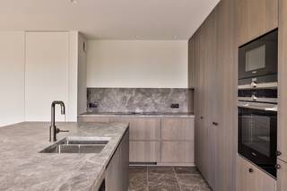 <p>In de Holstraat, op wandelafstand van het centrum van Waregem, vinden we dit exclusieve appartement met een uniek zicht op het kasteel van Potegem. Deze topligging biedt de perfecte combinatie van rust, groen en stedelijk comfort. Winkels, horeca, scholen en openbaar vervoer liggen vlakbij, terwijl u geniet van een panoramisch uitzicht en een luxueuze woonervaring.</p>

<p><strong>Over het appartement</strong><br />Dit instapklare appartement bevindt zich op de eerste verdieping van een recente residentie en werd afgewerkt met <strong>hoogwaardige materialen</strong>. De lichtrijke leefruimte sluit aan op een volledig uitgeruste open keuken met kookeiland en <strong>high-end toestellen</strong>. Het appartement beschikt over twee volwaardige slaapkamers en twee stijlvolle badkamers met verfijnde Mortex-afwerking. Op maat gemaakte ingemaakte kasten zorgen voor praktische en elegante opbergruimte doorheen het hele appartement.</p>

<p><strong>Indeling</strong><br />Inkomhal met gastentoilet en vestiaire, ruime leefruimte met veel lichtinval, open keuken met eetgedeelte, berging/wasplaats, twee slaapkamers, beiden met ensuite badkamer en zonnig terras met prachtig uitzicht.</p>

<p><strong>Kenmerken &amp;amp; troeven</strong></p>

<ul><li>Hoogwaardige afwerking en instapklaar</li><li>Vloerverwarming via warmtepomp</li><li>Airco in beide slaapkamers</li><li>Stijlvolle badkamers in Mortex</li><li>Grote raampartijen en veel lichtinval</li><li>Zicht op het kasteel van Potegem en de bibliotheek van Waregem</li><li>Centrale ligging in Waregem</li><li>Verkoop onder registratierechten (geen btw)</li><li>Mogelijkheid tot bijkopen van inpandige garage en/of buitenparking</li></ul>

<p>Dit appartement is ideaal voor wie houdt van luxe, rust en een topligging in het centrum van Waregem.<br />Meer informatie? Contacteer Maxime De Baere via 0491/92.11.86</p>