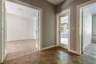 <p>JAN VAN RIJSWIJCKLAAN 83, 2018 ANTWERPEN</p>
<p>Gelegen op de tweede verdieping van een karaktervol gebouw, biedt dit ruime appartement een mooie combinatie van authenticiteit en potentieel. Originele elementen zoals de houten vloeren, hoge plafonds en authentieke haarden zorgen voor een warme en charmante uitstraling. De royale leefruimtes genieten van veel lichtinval en bieden een aangename woonbeleving.</p>
<p>Aan de achterzijde van het appartement bevindt zich een gezellig terras met een mooi uitzicht op het omliggende groen.</p>
<p>Het appartement beschikt verder over drie volwaardige slaapkamers en twee badkamers. Daarnaast zijn er een kelderberging, een autostaanplaats, een dubbele garagebox en twee extra meidenkamers aanwezig, die flexibel kunnen worden ingericht als berging, hobbyruimte of bureau. Deze laatste zijn verplicht aan te kopen bij het appartement als één geheel.</p>
<p>Hoewel het geheel op te frissen en te renoveren is, werden de daken reeds vernieuwd. Een eigendom met mooie volumes, authentieke charme en tal van mogelijkheden om het volledig naar eigen smaak vorm te geven.</p>