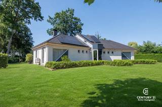<p><strong>Perfect onderhouden, energiezuinige gelijkvloerse villa waar comfort, rust en een prachtige tuin samenkomen</strong><span></span></p>
<p>Welkom in deze uitstekend onderhouden gelijkvloerse villa, waar kwaliteit, energiezuinigheid en wooncomfort centraal staan. Vanaf het eerste moment ervaart u de rust en het open gevoel dankzij het prachtige uitzicht op de fraai aangelegde, onderhoudsvriendelijke tuin die de woning volledig omringt. Vanuit vrijwel elke ruimte geniet u van een groen decor en een overvloed aan natuurlijk daglicht.</p>
<p>Via de verzorgde inkom met gastentoilet en vestiaire betreedt u de ruime leefruimte, waar grote raampartijen zorgen voor een uitzonderlijke lichtinval en een harmonieus contact met de tuin. De sfeervolle haardpartij vormt het warme middelpunt van de woonkamer, terwijl de energiezuinige warmtepompen zowel verwarmen als koelen en vandaag resulteren in een uitzonderlijk laag energieverbruik van slechts <strong>ongeveer € 9 per maand</strong>. Op koudere winterdagen zorgt de praktische pelletkachel bovendien voor extra gezelligheid. Vanuit de leefruimte heeft u rechtstreeks toegang tot het zonnige terras.</p>
<p>De volledig geïnstalleerde keuken is praktisch ingericht en beschikt over een gezellige ontbijthoek waar u tijdens het ontbijt kunt genieten van het zicht op de tuin en zelfs de eekhoorntjes tussen de bomen ziet rondlopen. Aansluitend bevindt zich een ruime wasplaats/berging met een rechtstreekse toegang tot de achtertuin.</p>
<p>De royale hoofdslaapkamer biedt alle comfort, met ingemaakte kasten, een eigen warmtepomp en een aansluitende badkamer uitgerust met een ligbad met douche, dubbele wastafel en bidet. Vanuit de centrale hal bereikt u bovendien een polyvalente ruimte die vandaag ingericht is als bureau. Via deze ruimte leidt een trap naar de bovenverdieping en beschikt u tevens over een tweede douchekamer met wastafel – ideaal voor gasten of thuiswerkers.</p>
<p>Op de verdieping bevinden zich een tweede slaapkamer en meerdere extra kamers die perfect dienst kunnen doen als berging, hobbyruimte of archiefruimte.</p>
<p>Ook buiten laat deze villa niets te wensen over. De verzorgde oprit, fraaie terrassen, garage, carport, overdekt terras en talrijke bergruimtes maken het geheel bijzonder compleet. De prachtig aangelegde tuin met kleurrijke bloemen, sierbeplanting en diverse fruitbomen vormt zonder twijfel de kers op de taart. Hier geniet u het hele jaar door van rust, privacy en een uitzonderlijk aangename leefomgeving.</p>
<p><strong>Een instapklare villa waar energiezuinig wonen, optimaal comfort en een schitterende tuin perfect samenkomen – een woning die u elke dag opnieuw laat genieten.</strong></p>