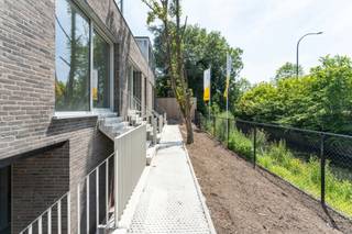 Lot 9 bevindt zich aan het uiteinde van het gebouw en geniet daardoor van een bijzonder open gevoel. De ruime leefruimte, twee slaapkamers en private buitenruimte zorgen voor een aangename woonkwaliteit. De combinatie van grote raampartijen, verfijnde materialen en opvallende architecturale volumes maakt van deze woning een echte blikvanger binnen het project.