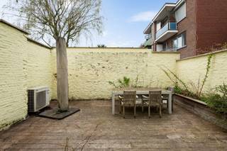 Deze uitstekend, rustig en strategisch gelegen woning bevindt zich op een gegeerde locatie nabij het Rivierenhof, een uitgestrekt en veelzijdig park waar natuur, ontspanning en recreatie samenkomen. Dankzij de combinatie van rust, groen en een vlotte bereikbaarheid naar in- en uitvalswegen geniet u hier van een bijzonder aangename woonomgeving.<br /><br /><strong>Indeling</strong><br /><br />De woning wordt betreden via de inkomhal of via de inpandige garage met automatische poort. In de inkomhal met vestiairegedeelte en gastentoilet heeft u toegang tot een polyvalente ruimte, ideaal als bureau, hobbyruimte of extra slaapkamer, evenals een ruime berging met alle technische voorzieningen. Deze ruimte geeft rechtstreeks uit op de gezellige en zonnige stadstuin met overdekt terras.<br /><br />Op de <strong>eerste verdieping</strong> bevindt zich de leefruimte, bestaande uit een ruime en lichtrijke woonkamer met aansluitend de eetruimte en open keuken. De grote raampartijen zorgen voor een aangename lichtinval en versterken het open karakter van deze verdieping. Via de eetruimte bereikt u het ruime en zonnige terras, dat via een vaste trap verbonden is met de tuin.<br /><br />De <strong>tweede verdieping</strong> omvat twee bijzonder ruime slaapkamers, waarvan één met ingemaakte kasten en de andere met een geïntegreerd bureau. Deze verdieping biedt bovendien de mogelijkheid om een derde slaapkamer te creëren. De badkamer is uitgerust met een ligbad met douchefunctie, lavabomeubel, toilet en voldoende opbergruimte.<br /><br /><strong>Bijzonderheden</strong><br />+ 21 zonnepanelen<br />+ Verwarming via warmtepomp (lucht-water en lucht-lucht)<br />+ Warmtepompboiler<br />+ Elektriciteit conform<br />+ Gezellige stadtuin en terras<br />+ Volledige UTP-bekabeling<br />+ Rolluiken en screens aanwezig