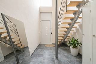 Deze woning met praktijkruimte/winkel is perfect voor wie wonen en werken wil combineren. U heeft hier scholen, winkels en openbaar vervoer binnen handbereik en ook de A12 is vlot bereikbaar. De handelsruimte, is vanaf de straatzijde toegankelijk via een aparte glazen deur en is verder voorzien van een grote glaspartij, dewelke perfect als etalage gebruikt kan worden. Vooraan bevindt zich een open ruimte, waarmee tal van mogelijkheden zijn. Achteraan is er een keuken, voorzien van aansluitingen voor wasmachine en droogkast en een apart toilet aanwezig. In de directe omgeving zijn er voldoende mogelijkheden om de wagen eenvoudig te parkeren. Het duplex-appartement beschikt over een aparte inkomhal met tegelvloer, vanwaar een trap leidt naar het leefgedeelte op de 1e verdieping. Achteraan de inkomhal is nog een handige wasplaats voorhanden met een deur die toegang verleent tot de tuin. De woonkamer op de 1e verdieping kan genieten van heel wat lichtinval dankzij grote ramen aan de straatzijde. De gerieflijk ingerichte keuken staat in open verbinding met de leefruimte en kan eveneens genieten van een aangename lichtinval. Verder is op de 1e verdieping nog een ruime slaapkamer, een apart toilet en een badkamer met inloopdouche en wastafel met meubel aanwezig. Een vaste trap leidt verder naar de 2e verdieping, waar u bovenkomt in een nachthal. Deze hal vormt de verbinding tussen 2 grote slaapkamers. Het totale perceel heeft een oppervlakte van 250m². In de aangename tuin georiënteerd op het noorden is het heerlijk vertoeven.