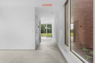 Prachtige halfopen nieuwbouwwoning in Lubbeek. Combineert hedendaags wooncomfort met een landelijke omgeving, terwijl Leuven, het industrieterrein Haasrode, AB-Inbev, IMEC, UZ Leuven,... dichtbij liggen. Via het fietsknooppuntennetwerk, dat vlak aan de woning start, bereikt u Leuven eenvoudig met de fiets. Ook de E40 is vlot bereikbaar en er bevindt zich een bushalte aan de woning. Bovendien liggen het centrum van Lubbeek en de Diestsesteenweg, met tal van winkels en grootwarenhuizen, op korte afstand. De woning werd ontworpen met oog voor ruimte, licht en energiezuinigheid. Ruime en lichtrijke leefruimte met volledig ingerichte open keuken. Dankzij de grote raampartijen geniet u van een aangenaam zicht op de tuin en een binnenpatio. Op de verdieping bevinden zich drie volwaardige slaapkamers, waarvan één met een volledig ingerichte dressing, en een comfortabele badkamer. De woning beschikt over een eigen perceel zuidgericht tuin/bos van ongeveer 2.000 m². Daarnaast beschikt elke woning over een eigen tuinhuis. Op technisch vlak is deze nieuwbouw (eerste bewoning) volledig uitgerust met alle hedendaagse comfort, waaronder zonnepanelen, vloerverwarming, een lucht-waterwarmtepomp, een ventilatiesysteem type D, een regenwaterput en een laadpaal voor elektrische voertuigen. De huurprijs bedraagt €1.950 per maand, aangevuld met een vaste kost van € 50 per maand voor de gemeenschappelijke kosten (tuin). Meer informatie: info@homies.be.