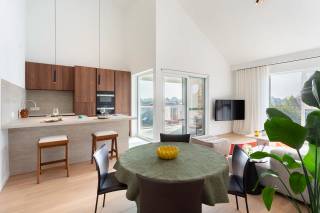 In het rustige Begijnhof van Stabroek bevindt zich dit stijlvol en energie-efficiënt appartement op de tweede verdieping van een kleinschalige residentie. Een lift brengt u rechtstreeks van de kelder of het gelijkvloers tot aan de inkomdeur.<br /><br />De leefruimte geniet van een bijzonder ruimtelijk gevoel dankzij een plafondhoogte van 5 meter en een afwerking met massieve eiken parket. De open keuken is uitgerust met hoogwaardige inbouwtoestellen: een Quooker-kraan, Miele oven en stoomoven, vaatwasser, en een Bora inductiekookplaat met geïntegreerde dampkap. Het werkblad in keramische travertijn is onderhoudsvriendelijk én esthetisch sterk.<br /><br />De badkamer is afgewerkt in dezelfde keramische travertijnlook en voorzien van een uitgekapte inloopdouche en een half vrijstaand ligbad. De afwerking van vloer tot plafond zorgt voor een uniforme, rustige uitstraling.<br /><br />Er zijn twee volwaardige slaapkamers, beide voorzien van elektrische Veluxramen die natuurlijke lichtinval en comfort optimaliseren. Zowel de slaapkamers als de leefruimte beschikken over airconditioning.<br />Extra comfort wordt geboden door zonwerende screens in de leefruimte en badkamer, en op maat gemaakte vliegenramen in heel het appartement. Recent schilderwerk en een volledige afwerking met stijlvolle verlichting maken deze woning volledig instapklaar.<br /><br />Bij het appartement horen twee autostaanplaatsen met laadpunt (à €27.500 per stuk), en een privatieve, afgesloten garagebox met sectionaalpoort (€37.500).<br /><br />Interesse?<br />Contacteer LISTED voor een bezoek: +32 3 283 51 51.<br />
