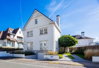 Deze prachtige alleenstaande villa is gelegen op een bijzonder gegeerde locatie, op slechts enkele passen van de Zeedijk. De eigendom onderscheidt zich door haar royale volumes, stijlvolle afwerking en doordachte indeling, met maar liefst vijf slaapkamers, meerdere badkamers, uitnodigende zonneterrassen en een aangename tuin.<br /><br />Indeling:<br />Gelijkvloers: ruime en verzorgde inkomhal met vestiaire en afzonderlijk gastentoilet. De sfeervolle leefruimte geniet van een overvloed aan natuurlijk licht en biedt rechtstreeks toegang tot het zonnige terras en de tuin. De aansluitende eetruimte en volledig uitgeruste open keuken vormen samen een harmonieus geheel, waar gezelligheid en functionaliteit centraal staan.<br /><br />Eerste verdieping: op deze verdieping bevindt zich de royale hoofdslaapkamer, voorzien van ingemaakte kasten en een luxueuze privébadkamer met douche, dubbele wastafel, toilet en sauna. Vanuit de slaapkamer is er directe toegang tot een heerlijk zonneterras. Daarnaast beschikt deze verdieping over een tweede ruime slaapkamer met maatkasten en een eigen badkamer, uitgerust met een inloopdouche en dubbele wastafel.<br /><br />Tweede verdieping: hier bevinden zich twee bijkomende volwaardige slaapkamers, waarvan één bijzonder ruim en voorzien van ingemaakte kasten. De andere slaapkamer biedt voldoende plaats voor twee afzonderlijke bedden. Een aparte badkamer met ligbad, wastafel en toilet vervolledigt deze verdieping.<br /><br />Kelderverdieping: de villa is volledig onderkelderd en beschikt hier over een vijfde slaapkamer met eigen douchekamer. Daarnaast zijn er verschillende bijkomende ruimtes die zorgen voor extra bergruimte en praktische mogelijkheden.<br /><br />Parkeergelegenheid: een ruime garage en een private oprit met parkeermogelijkheid voor twee extra wagens bieden alle comfort voor bewoners en gasten.<br /><br />Contacteer ons voor bijkomende informatie of een vrijblijvend bezoek.