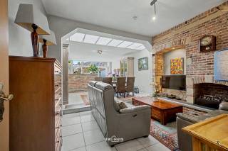 Deze instapklare en goed onderhouden rijwoning met karaktervolle trapgevel – haast een klein kasteeltje – bevindt zich in het hart van Sint-Niklaas en vormt de ideale starterswoning voor wie comfort en ligging wil combineren.
Met een bewoonbare oppervlakte van 133 m² biedt deze woning een lichtrijke leefruimte met gezellige niveauverschillen, naadloos aansluitend op een open keuken die voorzien is van alle hedendaagse comfort. Vanuit de leefruimte geniet u van een aangenaam zicht op het terras en de verzorgde stadstuin met praktisch tuinhuis.
Op de verdiepingen bevinden zich drie ruime slaapkamers, een badkamer met lavabomeubel, ligbad en tweede toilet, en extra bergruimte. De woning beschikt daarnaast over twee toiletten, een handige berging en een vaste trap naar elke verdieping.
Technisch is alles in orde: dubbele beglazing, dakisolatie en een condenserende gasketel zorgen voor een gunstig EPC van 201 kWh/m² (net geen label B).
Dankzij de centrale ligging, vlakbij winkels, scholen, openbaar vervoer en op wandelafstand van de Grote Markt, geniet u hier van een uitstekende bereikbaarheid. Vlotte verbindingen naar E17, N16 en N41 en parkeermogelijkheden in de straat maken het plaatje compleet. Bel of mail ons nu voor een afspraak op het nummer: 052/46.38.03 of info@uw-huis.be en wie weet tot binnenkort! 
