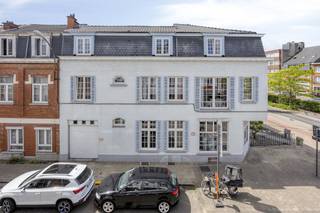 Op het gelijkvloers vind je een ruime, lichtrijke commerciële ruimte met grote raampartijen op de hoek, ideaal voor vrije beroepen met...