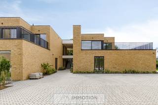 Dit woonproject bestaat uit zes geschakelde woningen, waarvan vier gelijkvloerse met elk een privé terras en tuin, en twee woningen op de eerste verdieping met elk een privé terras.<br /><br />De gelijkvloerse <strong>woning nummer 1</strong> is als volgt ingedeeld: inkomhal met toilet, afzonderlijke keuken met woonkamer, aansluitend twee terrassen en een private tuin, twee slaapkamers, een badkamer en een berging.<br /><br />Iedere woning heeft zijn parkeerplaats en een gemeenschappelijk fietsenstalling is voorzien.<br /><br />Deze woning wordt instap klaar opgeleverd: geschilderd en voorzien van lichtarmaturen.<br /><br />Het tuinonderhoud is inbegrepen in de maandelijkse kosten.<br /><br />U kunt deze woningen bezoeken op zaterdagvoormiddag, uitsluitend op afspraak.<br /><br />Voor een afspraak kunt u een e-mail sturen naar olivier@immotion.be.