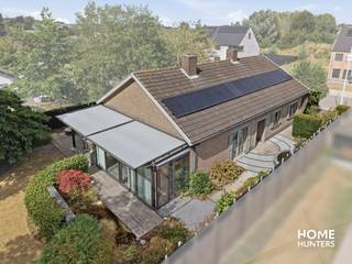 Op zoek naar een instapklare &amp; gelijkvloerse woning waar ruimte en kwaliteit centraal staan? Dan is deze smaakvol afgewerkte open bebouwing absoluut een bezoek waard. De woning beschikt over royale leefruimtes, een prachtige architecturaal aangelegde tuin en een hoogwaardige afwerking. Dit alles op een rustige ligging op wandelafstand van winkels en scholen.<br /><br />Bij het betreden van de woning komt u terecht in een ruime inkomhal met twee praktische inbouwkasten. De lichtrijke leefruimte vormt samen met de gezellige veranda het hart van de woning. De veranda is uitgerust met dubbele beglazing, automatische ventilatie en elektrische zonwering en biedt een prachtig uitzicht op de architecturaal aangelegde zuidwest-gerichte tuin met sierlijke vijvers. Ook buiten geniet u optimaal dankzij de pergola met zonwering, de barbecue met pizzaoven en de sfeervolle tuinverlichting.<br /><br />De kwalitatieve eiken keuken met duurzaam Dekton werkblad beschikt over heel wat kastruimte en is volledig uitgerust met ingebouwde toestellen. Aansluitend bevindt zich een gezellige eethoek en een praktische berging.<br /><br />Verder beschikt de woning over drie volwaardige slaapkamers met inbouwkasten, een aparte bureau of polyvalente ruimte, een stijlvolle badkamer met douche, ligbad, nieuw hangtoilet en ventilatie, evenals een ruime garage.<br /><br />Een absolute troef is de enorme zolderverdieping met een vrije stahoogte van ongeveer 2 meter. Deze biedt tal van mogelijkheden voor het creëren van extra slaapkamers, hobbyruimte of een thuiskantoor.<br /><br />Ook op technisch vlak scoort deze woning uitstekend. Zo beschikt ze over 16 zonnepanelen (5.120 kWh), een recente condenserende aardgasketel, overal dubbele beglazing, geïsoleerde buitenmuren en zoldervloer, een regenwaterput van 10.000 liter met drievoudig filtersysteem, een gekeurd alarmsysteem en een verandascreen.<br /><br />Extra troeven:<br /><br />- Open bebouwing met veel privacy<br />- Architecturaal aangelegde Zuidwest-gerichte tuin<br />- Drie slaapkamers met inbouwkasten<br />- Mogelijkheid tot extra kamers op de zolder<br />- Ruime garage, tuinhuis en fietsenberging<br />- Open haard<br />- 16 zonnepanelen<br />- EPC-label C (278 kWh/m²) – geen renovatieverplichting<br />- Asbestveilig attest beschikbaar<br />- Geen aanwijzingen van bodemverontreiniging<br />- Overstromingsscore A voor zowel perceel als woning<br />- Rustige ligging op wandelafstand van winkels en scholen<br /><br />Een woning waar ruimte en een uitzonderlijke tuin samenkomen. Ideaal voor wie zonder zorgen wil verhuizen naar een kwalitatieve gezinswoning met alle comfort en uitbreidingsmogelijkheden.