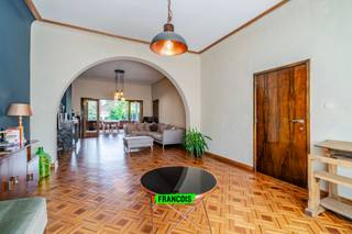 CHARME. AUTHENTICITEIT. KARAKTER. RUIMTE. LICHT. GEZELLIGHEID.<br /><br />In het dorpshart van Bassevelde treffen we deze unieke vastgoedparel aan waarvoor woorden tekort schieten. De woning met maar liefst 6 slaapkamers en gelijkvloersbureau werd gebouwd in 1935 door de familie Steyaert en kende doorheen de jaren heel wat voorname eigenaars. Bovendien heeft deze eigendom de rechtmatige stempel van beschermd erfgoed.<br /><br />GESCHIEDENIS EN STIJL<br /><br />De intact bewaarde woning van 1935 op het dorpsplein is een representatief voorbeeld van baksteenarchitectuur aansluitend bij het Romantisch kubisme, een stijlrichting in het interbellum die verwijst naar de architectuur van Nederlandse architect W.M. Dudok. Vooral het verzorgde baksteenparement met typische Dudokvoeg, de originele metalen ramen, de smalle hoge vensters met geometrische glas-in-loodvulling die het trappenhuis verlichten en de afgeronde hoeken van het ijzeren balkon zijn herkenbare stijlelementen. <br /><br />Het huis is vooral uitzonderlijk door de gaafheid en authenticiteit van het kwaliteitsvol art-deco-interieur dat als een totaalconcept gerealiseerd werd. De rijkdom aan gebruikte materialen, marmer voor de vloer in de gang en de schouwen, tropisch hout voor de parketvloeren en de trap, kleurige wandtegels, glas-in-lood voor de binnendeur en hoge vensters in het trappenhuis en de verzorgde afwerking van het binnenschrijnwerk en de decoratieve aankleding, ook van de nagelvaste elementen als de radiatorbeschermers en de cosy-corner, getuigen van kwaliteit en een stijlbewuste eigentijdse smaak. <br /><br />Door zijn beeldbepalende inplanting op het dorpsplein, in het gezichtsveld van de parochiekerk, de kiosk en het oorlogsgedenkteken en door zijn vrij uitzonderlijke moderne bouwstijl in deze landelijke context is het gebouw een goed herkenbaar component in de dorpskom. <br /><br />De achterliggende garage en de diepe tuin dateren uit dezelfde periode en getuigen van een zelfde totaalconcept, kenmerkend voor het interbellum. De tuinaanleg met terrassen, formeel vijvertje en talrijke groenblijvende bomen en struiken maken integrerend deel uit van de interbellumwoning.<br /><br />HEDEN <br /><br />Op vandaag kent dit imposante woonhuis een staat die reeds grotendeels gerenoveerd werd binnen de ruime renovatiemogelijkheden die aan beschermde eigendommen geboden wordt. Hierbij werden de ramen, verwarmingsinstallatie en elektriciteit (conform) vernieuwd. Ook de waterleidingen en plakwerk werden deels herwerkt. Daarnaast werd er ook dakisolatie aangebracht en spreken we over een quasi-asbestvrije toestand en uiteraard geen renovatieverplichting. Eventuele verdere werkzaamheden kunnen in aanmerking komen voor subsidies.<br /><br />UW TOEKOMST?<br /><br />Biedt deze unieke en charmevolle woonst de oppervlakte, buitenruimte en gezelligheid die u zoekt? Neem dan vrijblijvend contact op met Louis Van Zele van Immo Francois Meetjesland voor meer informatie of een bezoek.<br /><br />TROEVEN<br /><br /><ul><li>Gerenoveerd met aandacht voor de stijl<br /><br /></li><li>Open zicht op het dorpsplein<br /><br /></li><li>Grote en lichtrijke ruimtes<br /><br /></li><li>Gunstige attesten EPC, asbest en elektriciteit</li></ul>