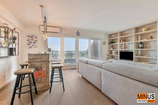 <p>TDeze instapklare duplex van ca. 130 m² is ideaal gelegen pal aan het station van Oostende, met trein, kusttram en bus in de onmiddellijke nabijheid. Een absolute topligging voor wie centraal wil wonen met maximale bereikbaarheid.</p>
<p>De leefruimtes bevinden zich op de zesde verdieping en bestaan uit een ruime, lichtrijke woonkamer met eetruimte en een volledig geïnstalleerde open keuken, aangevuld met een apart toilet en een praktische berging. Aansluitend geniet u van twee zonnige terrassen. Het oostgerichte terras aan de voorzijde biedt in de voormiddag zon en een fenomenaal uitzicht op de jachthaven, de Amandine en het historische stationsgebouw. Het westgerichte terras aan de achterzijde geniet zon van de middag tot de avond en kijkt uit op de spitsen van de Sint-Petrus-en-Pauluskerk.</p>
<p>Op de zevende verdieping bevinden zich drie volwaardige slaapkamers met inbouwkasten, een badkamer met inloopdouche, een tweede toilet en een lavabomeubel.</p>
<p>Het appartement werd gebouwd in 2001 en gerenoveerd in 2025. Dankzij het EPC-label A, privatieve zonnepanelen en een warmtepomp voor verwarming en koeling, die bovendien op afstand bedienbaar is, geniet u van een hoog wooncomfort en lage energiekosten. Verder zijn er een privatieve kelderberging en een gemeenschappelijke fietsenstalling.</p>
<p>Een unieke combinatie van ruimte, energiezuinigheid, zon en uitzicht op een uitzonderlijke centrale ligging aan de kust.</p>