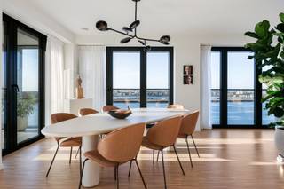 Welkom in een eigentijdse woonbeleving waar licht, ruimte en panorama centraal staan. Dit exclusieve appartement op de negende verdieping (2024) combineert modern comfort met een adembenemend uitzicht over de stad en de Schelde.

De leefruimte straalt openheid en rust uit, met een warme bamboeparketvloer en grote raampartijen langs drie gevels die zorgen voor uitzonderlijk veel natuurlijk licht. Het frontale zicht op de Schelde en het panoramische stadsbeeld maken elke dag bijzonder.

De volledig uitgeruste keuken verenigt functionaliteit en esthetiek en wordt aangevuld met een ruime bijkeuken. Aansluitend zijn er een noord- en zuidgericht terras en een winterterras, zodat u het hele jaar door van het buitengevoel geniet.

Het appartement telt twee slaapkamers: een master bedroom met ensuite badkamer en dressing, en een tweede kamer met douchekamer, ideaal als logeer- of bureauruimte. Een apart gastentoilet vervolledigt het geheel.

Twee inpandige parkeerplaatsen zijn beschikbaar aan €45.000 per stuk, exclusief btw. De aankoopprijs is eveneens exclusief btw.

Een lichtrijk en luxueus appartement in het hart van Antwerpen.