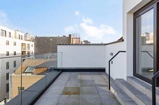 Deze gloednieuwe penthouse (4de verdiep) combineert verfijnde luxe met een unieke ligging in een stijlvol gebouw met een karaktervolle modernistische gevel, op amper enkele stappen van het strand en de winkelstraat. De lift brengt u rechtstreeks tot in het appartement, wat garant staat voor comfort en discretie.<br /><br />Indeling: lichtrijke leefruimte met toegang tot privatief zonneterras. De aparte keuken is uitgerust met kwalitatieve toestellen. Verder is er een handige berging voorzien. De eerste slaapkamer van 16 m² heeft een eigen badkamer met ligbad, wastafelmeubel en toilet. De tweede, grotere slaapkamer (19 m²) beschikt over een privé douchekamer met inloopdouche, dubbel wastafelmeubel en toilet. Daarnaast is er ook een apart gastentoilet.<br /><br />Het appartement is afgewerkt met hoogwaardige materialen en moderne comfortvoorzieningen.<br /><br />Er is tevens een privékelder inbegrepen. In het gebouw bevinden zich bovendien een ruime fietsenberging met verschillende oplaadpunten én een gemeenschappelijk dakterras dat de hele dag zon biedt.<br /><br />!!!!Verkoop valt onder registratierechten (geen BTW van toepassing).