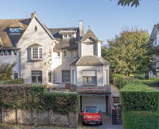 <strong>Karaktervolle cottagewoonst met tuin in de gegeerde Reginawijk te Dilbeek.</strong><br />Gelegen nabij scholen, winkelmogelijkheden, invalswegen op wandelsafstand van centrum Dilbeek.
<p>Deze statige woning in Anglo-Normandische cottagestijl ademt warmte en authenticiteit, ze werd +/- 17 jaar terug vanbinnen gerenoveerd met behoud van haar charme.</p>
<p>Er is een uitstekende verbinding met de Brusselse ring, E40 en meer. Dit biedt een sterke combinatie van<strong> </strong>een rustige residentiële ligging en vlotte bereikbaarheid.</p>
<p>Bij het binnenkomen langs de ruime inkomhal zijn er verscheidene ruimtes te bereiken, sas met vestiaire en handwasser in Carrara-marmer en afzonderlijke design-wc. Aan de voorzijde bevindt zich een bureel (7.7m²), ideaal voor thuiswerk of vrij beroep. <br /><br />Verder opent zich de gezellige woonkamer, voorzien van pellet-kachel en met een mooie parketvloer. Aansluitend ontdekken we de mooie, half-open keuken met werkblad in Belgische blauwe steen en kwalitatieve toestellen.<br /><br />Zowel de leefruimte als de keuken geven uit op het overdekte terras met eikenhouten pergola — een sfeervolle plek, in het verlengde van de leefplaatsen om het hele jaar door te genieten van de tuin.</p>
<p>De eerste verdieping biedt drie aangename slaapkamers (14 – 13 – 10 m²) en een gerenoveerde badkamer (+/-2008) (met douche, jacuzzi-ligbad een badkamermeubel met blad in Carrara-marmer) en een apart, tweede toilet. <br /><br />De vaste trap leidt verder naar de zolderverdieping, ingericht als extra, vierde slaapkamer of hobbyruimte met ingemaakte kasten en bijkomende zolderberging (10m²).</p>
<p>Ook op praktisch vlak scoort deze woning uitstekend. De volledige onderkeldering omvat vijf aparte kelderruimtes (voorzien van ventilatiesysteem) en een garage met voorliggende autostaanplaats. Er is stockageruimte, een wasplaats, conservenkelder en meer terug te vinden. <br /><br />De technische installaties van deze gezinswoning werden reeds gerenoveerd (elektrische installatie, afvoerleidingen, sanitair, verwarming met condenserende aardgasketel en gedeeltelijk ook de ramen).<br /><br />De aangename tuin is volledig omheind en voorzien van recent tuinhuis (elektriciteit voorzien).</p>
<p>Een bijzonder aangename woning met karakter, ruimte en gunstige aanpassingen door de jaren heen. En dat op een gewaardeerde locatie in Dilbeek.<br /><br />Deze eigendom is gekend als vastgesteld bouwkundig erfgoed (vrijstelling voor renovatieplicht, desondanks label F) meer informatie is terug te vinden via: <strong>https://www.onroerenderfgoed.be/het-goed-staat-een-vastgestelde-inventaris<br /><br /></strong>EPC 561 kWh/m² jaar<br />Code 3708061 - label F</p>