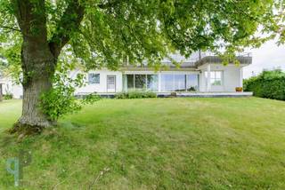 Deze karaktervolle voormalige dokterswoning (bouwjaar 1961) biedt een uitzonderlijke bewoonbare oppervlakte van maar liefst 439 m² en combineert ruimte, comfort en een strategische ligging langs de N60, centraal op de as Ronse – Oudenaarde.<br />De woning beschikt beneden over een indrukwekkend aanbod aan leef- en werkruimtes. Zo vindt u er een grote living met gashaard, een ruime keuken, een gezellig bureel, een bibliotheek, een praktische wachtzaal, een voormalige praktijkruimte, een opslagplaats en zelfs een wijnkelder. Dankzij deze veelzijdige indeling is de woning perfect geschikt voor grote gezinnen, zelfstandigen, vrije beroepen of wie gewoon graag royaal woont.<br />Boven beschikt de woning over 5 volwaardige slaapkamers, 2 badkamers en 4 toiletten. De vele ingemaakte kasten zorgen voor extra comfort en praktische opbergruimte.<br />Op technisch vlak geniet u van tal van hedendaagse voorzieningen, waaronder driedubbele beglazing, automatische poorten en rolluiken, een alarmsysteem, zonnepanelen en een verwarmingsinstallatie op aardgas.<br />Buiten wacht een aangenaam overdekt terras met daarboven een balkon, beide gericht op het mooie verzicht achteraan het perceel. De dubbele garage met sectionaalpoort biedt ruim plaats voor twee voertuigen en extra bergruimte.<br />Voor meer inlichtingen of een bezoek, contacteer Veronique 0483/676579