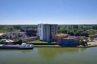Exclusief appartement in de iconische Silo's van Het Kanaal<br /><br />In het prestigieuze woonproject Het Kanaal, de internationaal gerenommeerde herontwikkeling van Axel Vervoordt aan het Albertkanaal, bieden wij een uitzonderlijk appartement aan in de iconische Silo's. Deze unieke residentie maakt deel uit van een architecturaal meesterwerk waar industrieel erfgoed, hedendaagse architectuur, kunst en natuur harmonieus samenkomen. Het Kanaal groeide uit tot een culturele en residentiële bestemming van internationale allure, ontworpen rond de visie van Axel Vervoordt en gerealiseerd door onder meer architect Stéphane Beel.<br /><br />Gelegen op de derde verdieping, geniet dit appartement van een prachtig uitzicht over het Albertkanaal en de zorgvuldig aangelegde omgeving van Het Kanaal. De woning beschikt over een royale leefruimte met grote raampartijen die zorgen voor een uitzonderlijke lichtinval en een directe connectie met het water en het omliggende landschap.<br /><br />Het appartement omvat:<br /><br />2 ruime slaapkamers<br />2 volwaardige badkamers<br />Een elegant inpandig terras met zicht op het kanaal<br />Hoogwaardige afwerking en tijdloze architectuur<br />Een unieke woonbeleving binnen een van de meest gegeerde residentiële projecten van België<br /><br />Wonen in de Silo's betekent deel uitmaken van een exclusieve gemeenschap waar architectuur, kunst en levenskwaliteit centraal staan. Op de site bevinden zich onder meer galerijen, tentoonstellingsruimtes en zorgvuldig geïntegreerde groene zones die Het Kanaal een uitzonderlijk karakter geven. Prijs staanplaats en berging in de kelderverdieping. (€25.000 en €15.000).