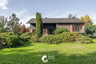 <p><strong><span>Karakteristieke woning met dubbele garage op een ruim perceel van 46 are 50 ca</span></strong></p>
<p><span>Deze karakteristieke woning uit 1964 is gelegen in een landelijke omgeving, op een steenworp van de Nederlandse grens. De woning bevindt zich op een ruim en volledig omheind perceel van maar liefst 46 are 50 ca, waar rust, privacy en ruimte centraal staan.</span></p>
<p><span>De woning werd gebouwd met duurzame en degelijke materialen en beschikt over een praktische split-levelindeling. Op het gelijkvloers bevinden zich een ruime inkomhal, een lichtrijke woon- en eetkamer, een ruime keuken en een multifunctionele bureauruimte. Op de verdieping zijn er drie ruime slaapkamers. Daarnaast beschikt de woning over een kelderverdieping met verschillende bergruimtes en sanitaire voorzieningen.</span></p>
<p><span>Een absolute meerwaarde zijn de ruime zolder van 131 m² boven de woning en de vrijstaande dubbele garage met een bijkomende zolderruimte van 51 m². Deze ruimtes bieden tal van mogelijkheden voor opslag of een verdere invulling naar eigen behoeften.</span></p>
<p><span>Ook buiten heeft deze eigendom heel wat te bieden. De tuin is aangelegd met gras- en tuinperken en een kleine vijver. Het volledige perceel is omheind met smeedwerk en toegankelijk via een voetgangerspoortje en een elektrische schuifpoort.</span></p>
<p><strong><span>Indeling:</span></strong></p>
<p><strong><span>Gelijkvloers:</span></strong></p>
<ul>
<li>
<p><span>Ruime inkomhal</span></p>
</li>
<li>
<p><span>Lichtrijke woon- en eetkamer</span></p>
</li>
<li>
<p><span>Ruime keuken met zicht op de tuin</span></p>
</li>
<li>
<p><span>Achterinkomhal </span></p>
</li>
<li>
<p><span>Bureauruimte naast de inkomhal</span></p>
</li>
</ul>
<p><strong><span>1ste verdieping:</span></strong></p>
<ul>
<li>
<p><span>Nachthal</span></p>
</li>
<li>
<p><span>3 ruime slaapkamers</span></p>
</li>
</ul>
<p><strong><span>Kelderverdieping:</span></strong></p>
<ul>
<li>
<p><span>Badkamer met douche en toilet</span></p>
</li>
<li>
<p><span>Apart toilet<br /></span></p>
</li>
<li><span>Bergruimte</span></li>
<li>
<p><span>Technische ruimte met verwarmingsketel</span></p>
</li>
<li>
<p><span>Rechtstreekse toegang naar buiten</span></p>
</li>
</ul>
<p><strong><span>Zolder:</span></strong></p>
<ul>
<li>
<p><span>Verder in te richten zolderruimte van 131 m²</span></p>
</li>
</ul>
<p><strong><span>Buitenruimte:</span></strong></p>
<ul>
<li>
<p><span>Tuin met gras- en tuinperken en een kleine vijver</span></p>
</li>
<li>
<p><span>Vrijstaande dubbele garage met zolderruimte van 51 m²</span></p>
</li>
<li><span>Achterzijde van garage is een stal voorzien</span></li>
<li>
<p><span>Volledig omheind perceel met smeedwerk</span></p>
</li>
<li>
<p><span>Elektrische schuifpoort en aparte toegangspoort</span></p>
</li>
</ul>
<p><strong><span>Troeven:</span></strong></p>
<ul>
<li>
<p><span>Rustige, landelijke ligging nabij de Nederlandse grens</span></p>
</li>
<li>
<p><span>Uitzonderlijk ruim perceel van 46 are 50 ca</span></p>
</li>
<li>
<p><span>Drie ruime slaapkamers en een bureauruimte</span></p>
</li>
<li>
<p><span>Maar liefst 182 m² aan bijkomende zolderruimte</span></p>
</li>
<li>
<p><span>Tal van mogelijkheden voor wie op zoek is naar ruimte, flexibiliteit en privacy<br /><br /></span></p>
</li>
</ul>
<p><span>Ben jij op zoek naar een karaktervolle woning met veel ruimte en potentieel? Neem contact met ons op voor meer informatie of een bezichtiging. We helpen je graag verder!</span></p>