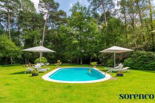 <strong>Op een van de meest prestigieuze locaties Hof ter Linden / Bellemond te Schilde, vindt u deze moderne en lichtrijke architectenvilla op een magnifiek perceel van 2.675m², gebouwd door architect John Bontinck. Gelegen in het groen maar tegelijkertijd centraal nabij de dorpskern, straalt deze villa een vakantiesfeer uit die doet denken aan de Côte d'Azur en de Provence.<br /><br />INDELING:<br /></strong>Bij binnenkomst via de INKOMHAL treft u een apart gastentoilet met handenwasser en een vestiaire. Een dubbele glazen deur biedt toegang tot de riante en lichte WOONKAMER met een majestueus raam dat doorloopt tot de verdieping. De leefruimte, opgesplitst in een zithoek, salon en eetkamer, is voorzien van een eiken parketvloer en een open haard, en biedt een wijds uitzicht op de tuin en het zwembad. U wordt direct gecharmeerd door het vakantiegevoel dat deze villa uitstraalt, waarbij de ruimtes mooi in elkaar vloeien. <br /><br />Aansluitend aan de leefruimte bevindt zich de volledig geïnstalleerde LEEFKEUKEN met een kookeiland, ontbijthoek, tal van opbergkasten en recente moderne toestellen, waaronder een dubbele spoelbak, kookplaat, dampkap, oven, Amerikaanse koelkast en afwasmachine. De keuken wordt overspoeld met natuurlijk licht door de kamerhoge raampartijen en biedt een prachtig uitzicht op de tuin. <br /><br />Tussen de keuken en de garage is een praktische DOUCHEKAMER, ideaal na een verfrissende duik in het zwembad. <br />De inpandige dubbele GARAGE biedt ruimte voor twee wagens en heeft een automatische toegangspoort. Daarnaast is er een ruime oprit met plaats voor meerdere wagens, wat extra gemak en parkeerruimte biedt voor u en uw gasten.<br /><br />Een elegante houten trap leidt naar de <span>eerste verdieping</span>. De overloop op parket geeft toegang tot de verschillende slaapkamers. Dankzij de vide baadt de gang in het licht en biedt het een uitkijkplaats over de magnifieke tuin.<br /><br />De MASTERBEDROOM heeft een ensuite walk-in dressing en ingerichte BADKAMER met ligbad, dubbele lavabo en een toilet. <br />SLAAPKAMER 2 ca. 31,20m² op parket met ingemaakte kasten geeft uit op een prachtig terras en biedt een prachtig uitzicht op de tuin. SLAAPKAMER 3 ca. 20,4m² en SLAAPKAMER 4 ca. 18,60m² delen de tweede BADKAMER met ligbad, lavabo en een toilet. <br />Verder is er nog een BERGING van ca. 3m², waar een extra douchekamer of wasplaats mogelijk is.<br /><br />Geniet volop van de zonnige tuin in privacy met een aangelegd terras, verwarmd zwembad en een tuinhuis. Deze buitenruimte biedt de perfecte setting voor ontspanning, zomerse barbecues en gezellige avonden. Beleef het ultieme vakantiegevoel zonder uw huis te verlaten. <br />
<p>Deze villa is een waar paradijs voor wie houdt van een luxe levensstijl met een vleugje vakantie. De ruime indeling en grote ramen zorgen voor een lichte en luchtige sfeer. <br /><br /></p>
<strong>BIJZONDERHEDEN:<br /></strong>* <span>Lichtrijke moderne architectenvilla gelegen in een prestigieuze villawijk te ‘s Gravenwezel.<br /></span>* Gebouwd door architect John Bontinck<br />* Conforme keuring (2025), 15 zonnepanelen (2024) , EPC: 164kWh/m², regenwaterput, vloerverwarming op het gelijkvloers, gevel geschilderd 2023, Bouwjaar 2000, asbestvrij.<br />* Parketvloeren, Bose-installatie<br />* Inpandige garage, oprit voor meerdere wagens, zolderberging, kelder <strong><br /></strong>