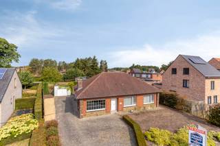 Deze woning is gelegen in de groene rand van Zandhoven. Winkels, openbaar vervoer, autosnelweg, bos, Albertkanaal liggen allen vlakbij.<br /><br />INDELING GELIJKVLOERS<br />Er is een inkomhal die overgaat in de nachthal.<br />Lichte leefruimte met toegang tot de keuken enerzijds en de veranda anderzijds.<br />Berging met aansluiting voor wasmachine naast de veranda en grenzend aan de tuin.<br />Twee slaapkamers aan de voorzijde van de woning.<br />Badkamer met voorzieningen voor mindervalide personen.<br /><br />Grote tuin rondom met aparte garage (éénvoudige materialen).<br /><br /><br />BIJZONDERHEDEN<br />ZOLDER boven de gehele woning. Te bereiken via zoldergat met ladder.<br />Deze zolder dient nu enkel voor berging maar kan nog ingericht worden mits er in een vaste trap voorzien wordt.<br />Een deel van de woning werd ONDERKELDERD, het overige deel werd voorzien van kruipkelder.<br />Isolatie dak: 120 mm minerale wol / muren: 50 mm EPS in de spouw.<br />Stedenbouwk. inlicht. zijn in aanvraag.<br /><br /><br />POSITIEVE ASPECTEN<br />EPC label: C.<br />Mooie ligging.<br />Gelijkvloers wonen.