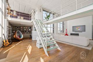 Located in this former wool mill, you’ll find this exceptional 340-square-meter loft, spread over two floors and finished with high-quality materials. A property that excels in space, light, and comfort. Beautiful terrace with a stunning view of the greenery and the landscape of the Flemish Ardennes.The first floor welcomes you with a stylish entry hall, a guest restroom, and an open, fully equipped kitchen with a cooking island. The spacious living area with a library flows seamlessly onto the sunny terrace, ideal for relaxation. This level also features a spacious bedroom with a luxurious bathroom (bathtub, shower, double sink, and toilet), a practical laundry room, and a storage room.On the second floor, you’ll find an impressive landing with a loft, two full-sized bedrooms, and a sauna. The second bathroom is equipped with a shower and double sink.The loft features two underground parking spaces and a spacious basement storage area.This unique residence combines modern finishes (hardwood floors, aluminum window frames, custom-made features, air conditioning, and electric blinds) with an excellent location near amenities, public transportation, and easy access to major roads.An exceptional opportunity for those seeking space, luxury, and character.For sale through Immo Beguin, your real estate expert since 2009. With offices in: Ronse, Waregem, Kortrijk, Lessines, Deinze, Tournai, Mouscron, and Nieuwpoort.✉️ info@immobeguin.be